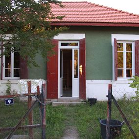 jardin et maison aux volets rouges